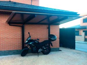 imagen de una marquesina KL de cubiertas y terrazas CyC Expert cubriendo una moto estacionada